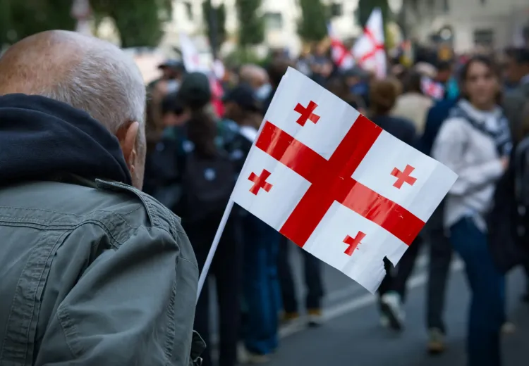 Man carries Georgian flag in crowd